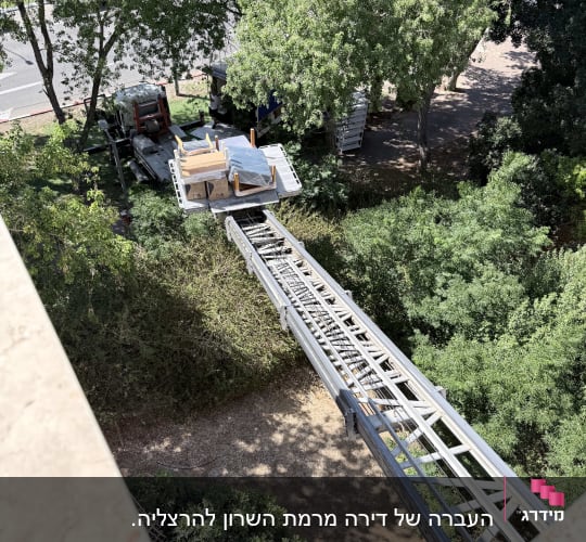 מנוף להובלת רהיטים ליד בניין ועצים